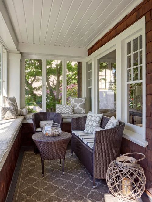 a porch with wicker furniture and large windows