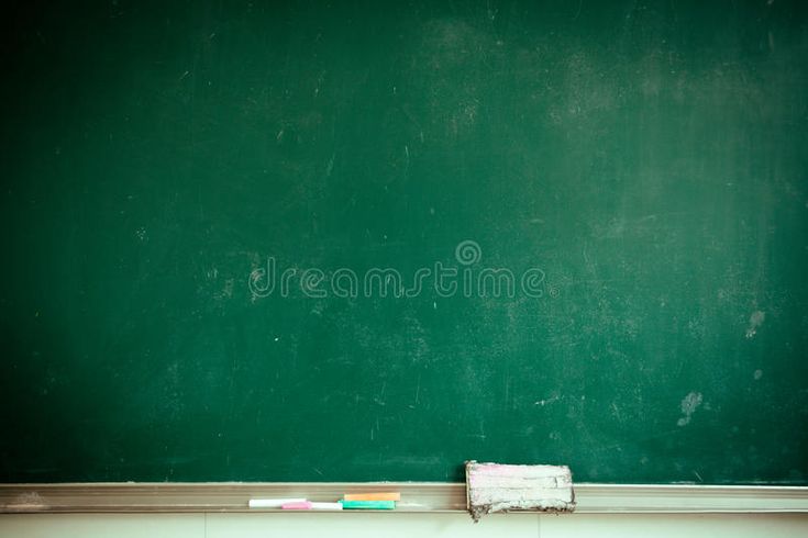 a green chalkboard with two toothbrushes on the floor in front of it