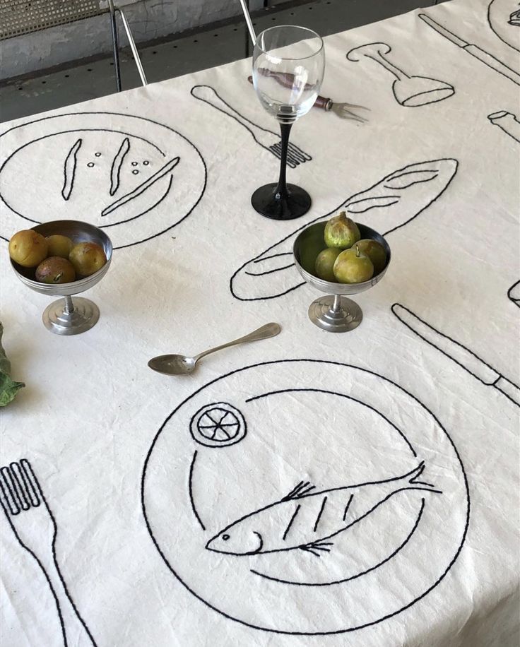 a table topped with plates and bowls filled with food next to utensils on top of a white table cloth