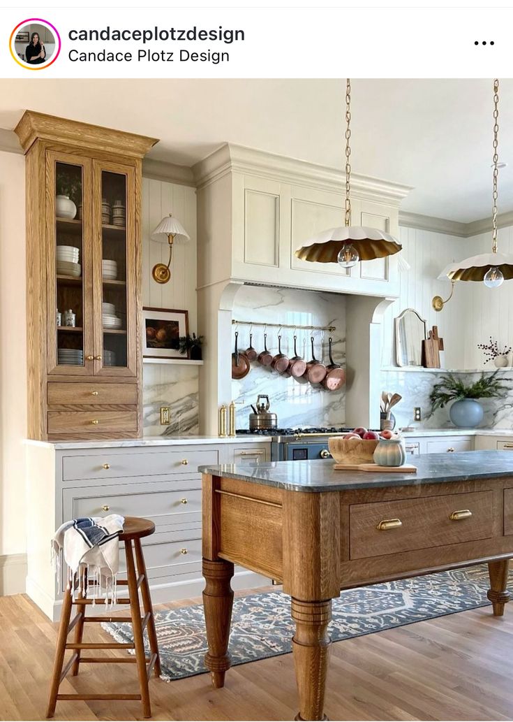 a kitchen with an island in the middle of it and wooden stools at the end