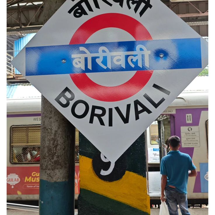 a sign that is on the side of a pole in front of a train station