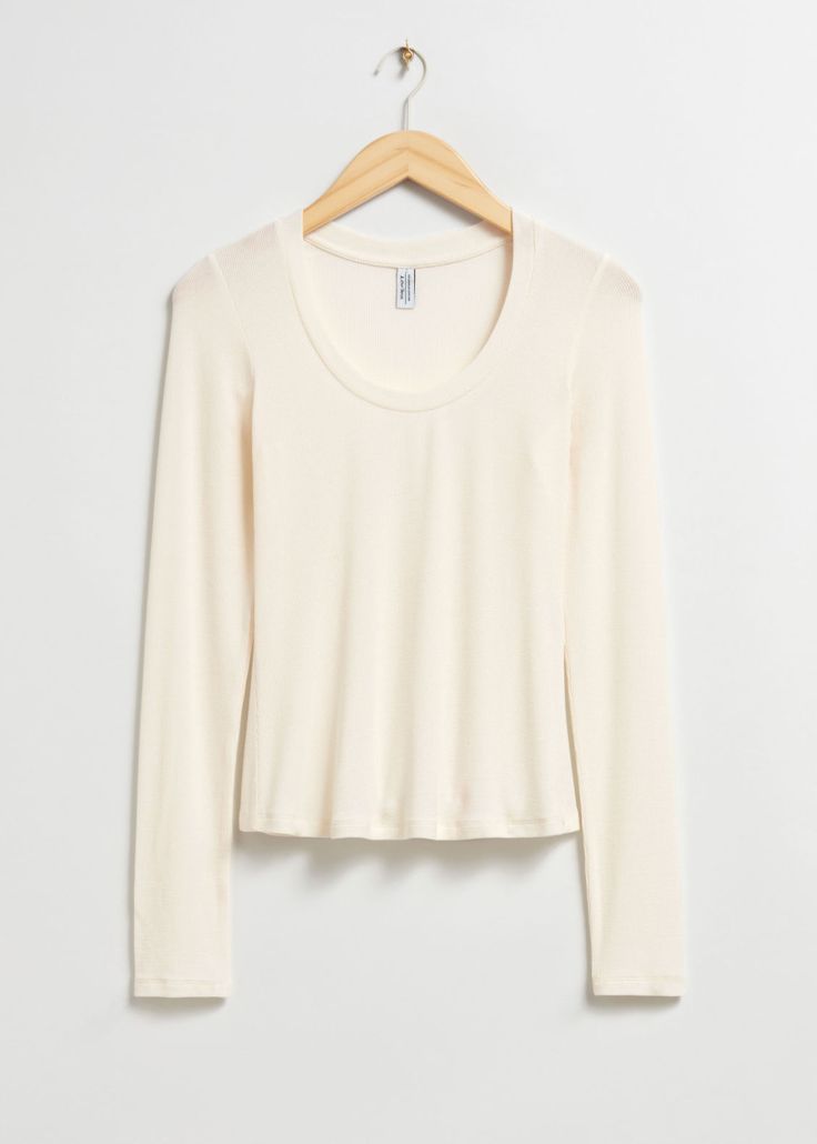 a white crop top hanging on a wooden hanger