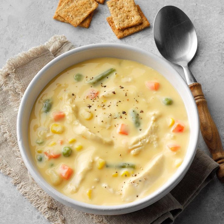 a bowl of soup with crackers on the side