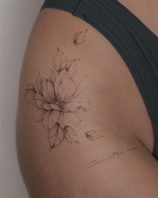 a woman's stomach with a flower tattoo on her left side ribcage