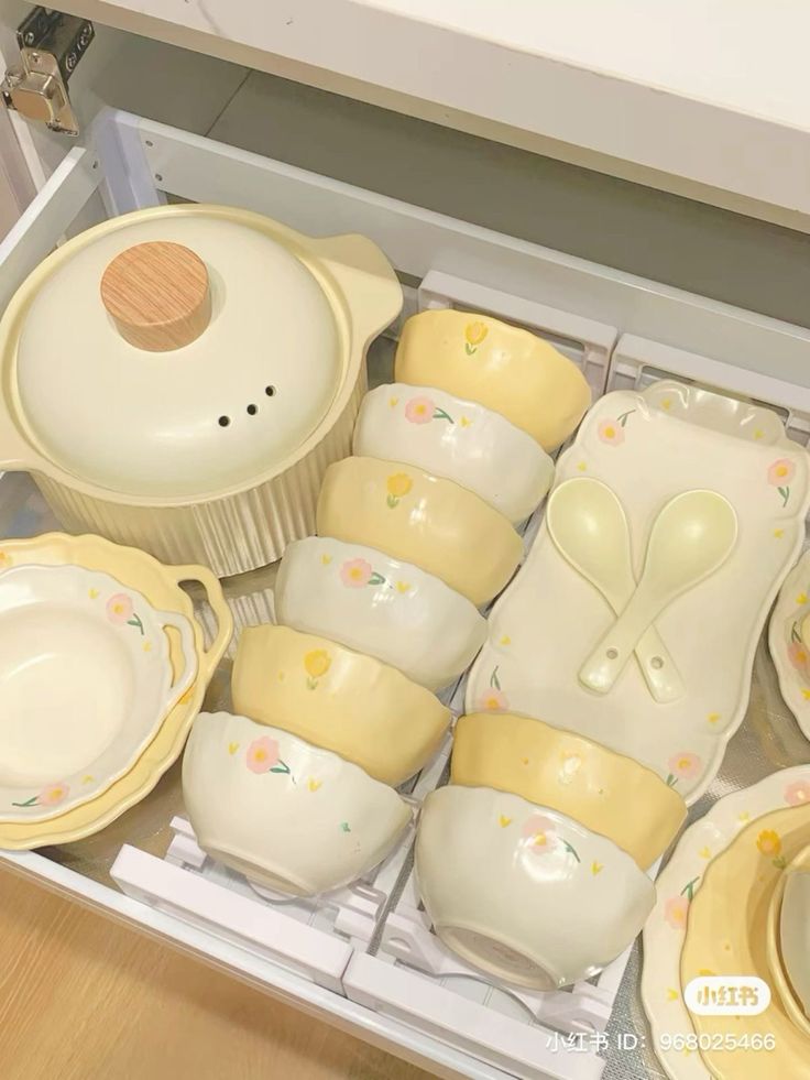 a drawer filled with yellow dishes and plates