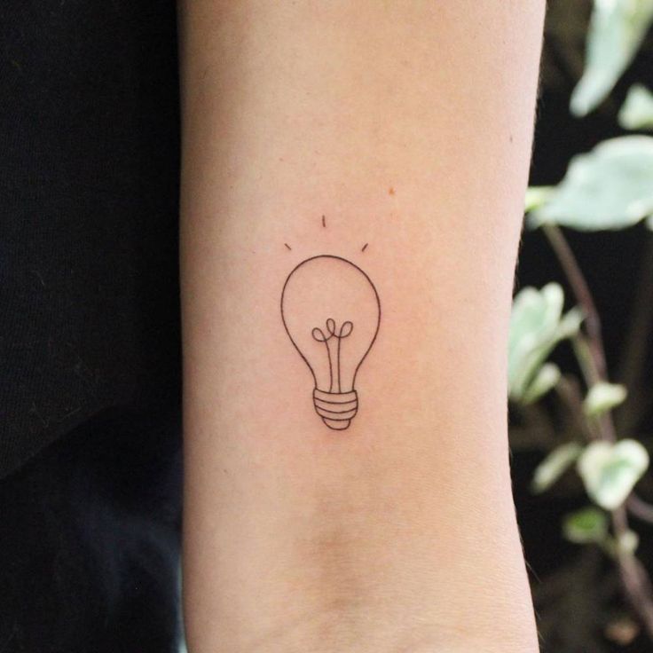 a small lightbulb tattoo on the right inner arm and wrist, which is black ink