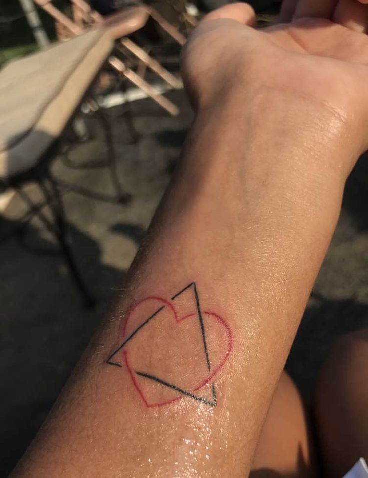 a person with a heart tattoo on their arm