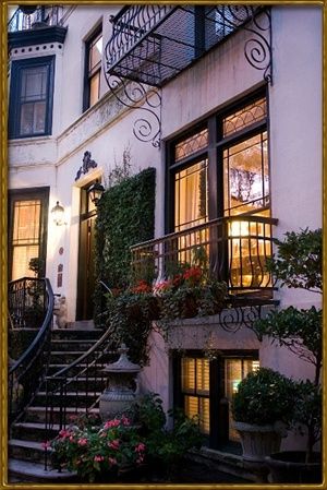 the stairs lead up to an apartment building with flowers growing on it's balconies