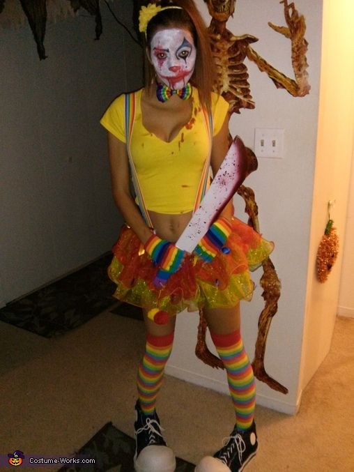 a woman dressed up as a clown holding a knife in her hand and wearing colorful makeup