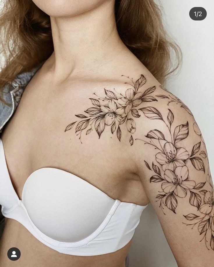 a woman wearing a bra with flowers on her chest and shoulder tattoo design in black ink