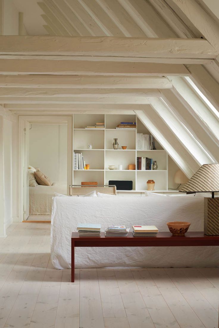 an instagram photo of a living room with white walls and ceilings, including bookshelves