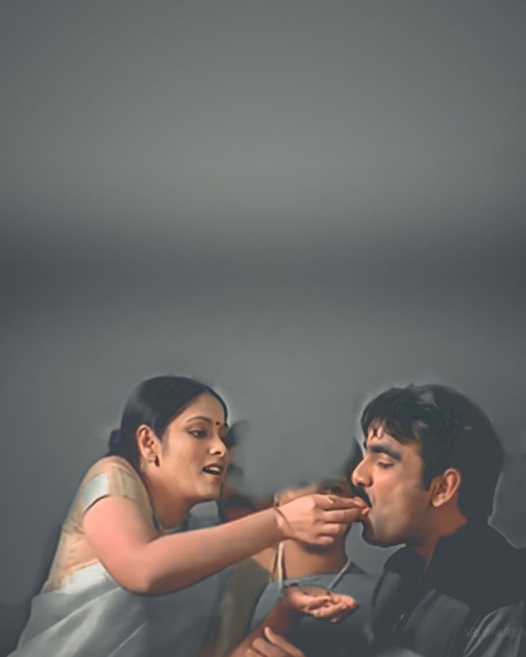 a man feeding a woman something with her hand