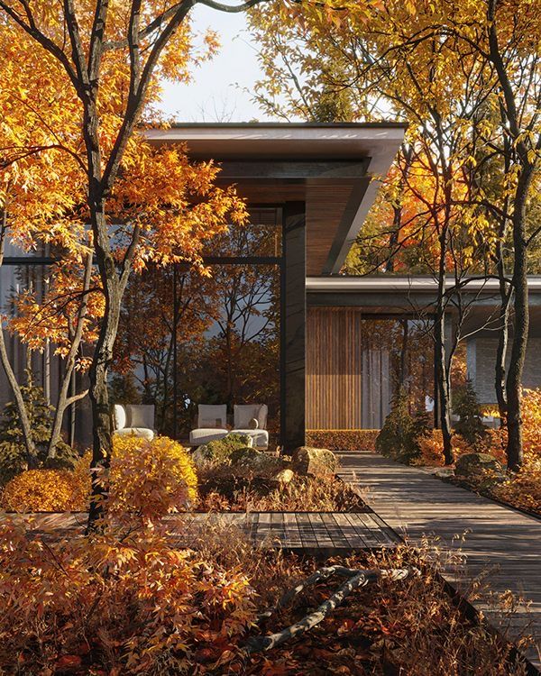 the house is surrounded by trees with yellow and orange leaves on it's branches