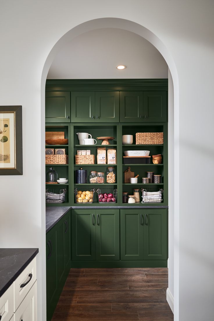 a kitchen with green cabinets and white walls