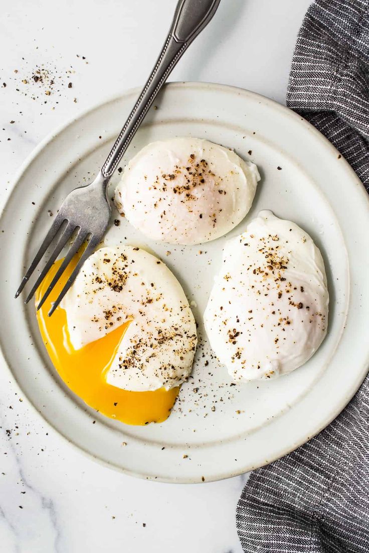 three eggs on a plate with an egg yolk drizzled over them