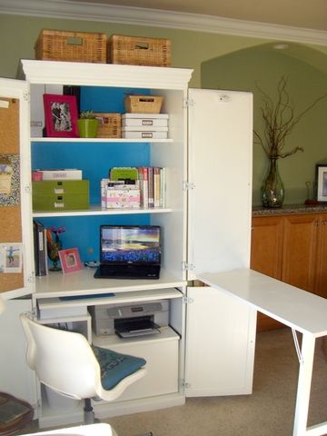 a white desk with a laptop computer on top of it next to a book shelf