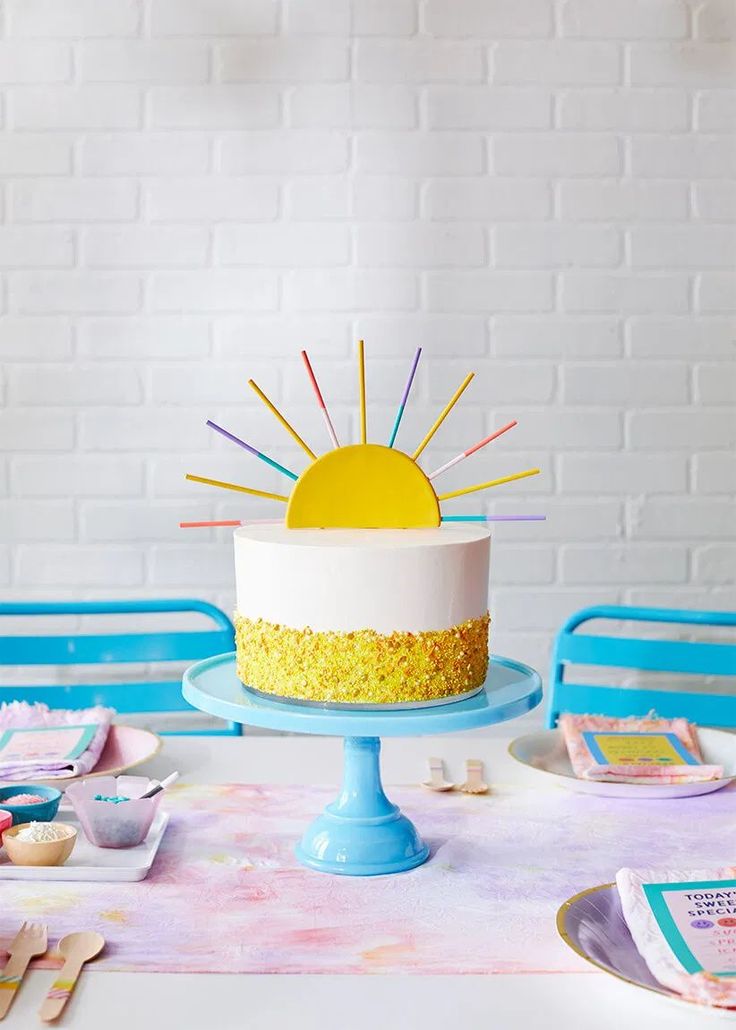 a white cake with yellow frosting and sprinkles sitting on a table