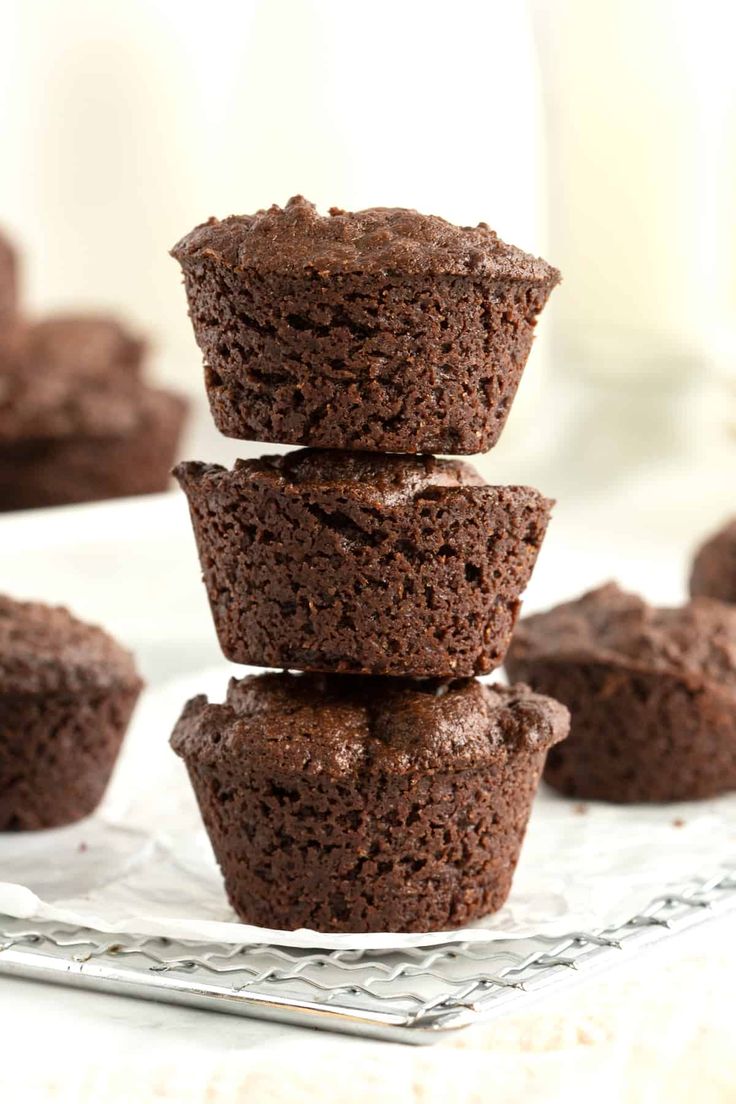 chocolate cupcakes stacked on top of each other with one cut in half to show the inside