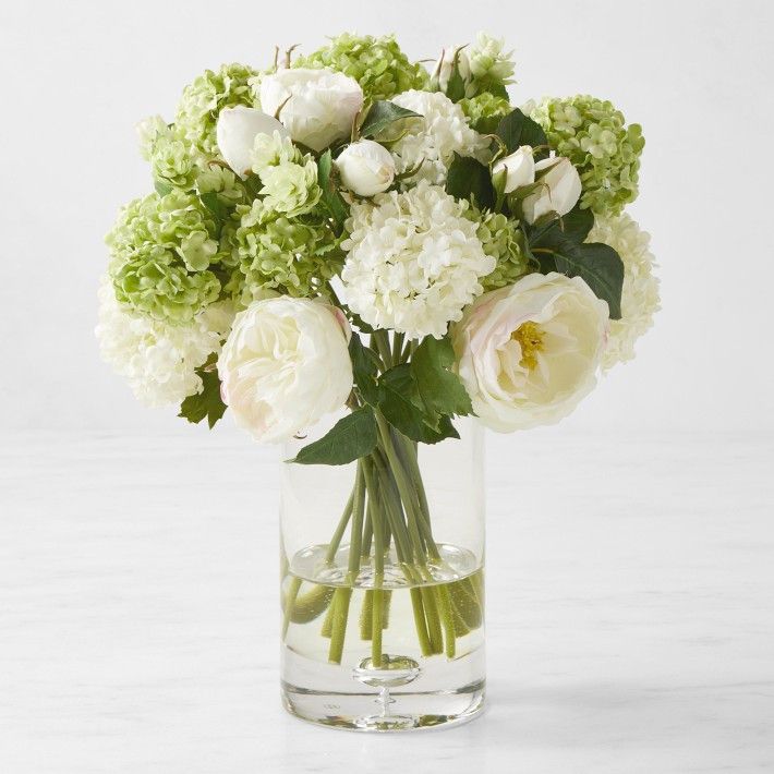 a vase filled with white and green flowers