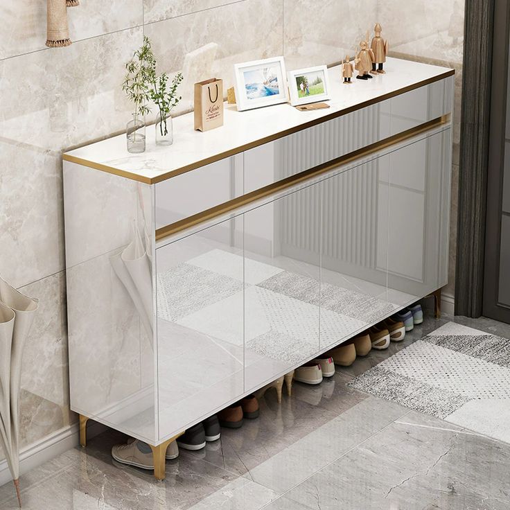 a white and gold sideboard in a room with shoes on the floor next to it