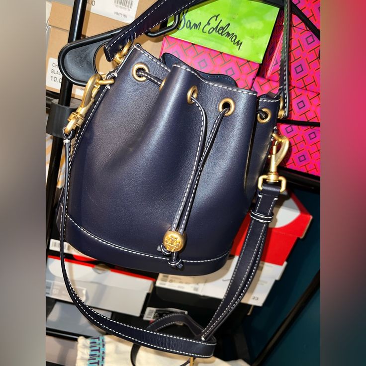 Navy Blue Tory Burch Bucket Bag. Comes With Detachable Shoulder Strap. Signature Symbol On Bottom Of Bag. Drawstring Clamp On Front Of Bag To Open & Close. This Big Bucket Bag Is Made To Fit All Essentials You Need In A Bag. Condition Is Good. No Scratches. Only Worn A Small Amount Of Times. Dust Bag Included! Price Is Solid! Height: 8.3" Length: 8.3" Depth: 4.7" Designer Blue Bucket Bag, Designer Blue Bucket Bag With Dust Bag, Blue Luxury Pouch Bucket Bag, Luxury Blue Bucket Bag With Adjustable Strap, Luxury Blue Pouch Bucket Bag, Luxury Blue Bucket Bag With Gold-tone Hardware, Designer Blue Bucket Bag For Travel, Blue Formal Bucket Bag, Formal Blue Bucket Bag