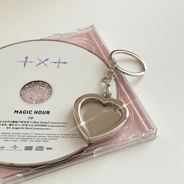 a cd with a heart shaped keychain attached to it's disc case