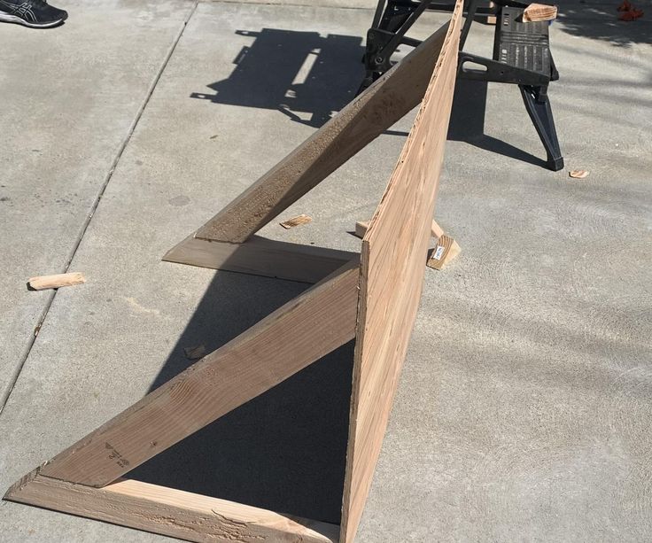 a wooden bench sitting on top of a sidewalk