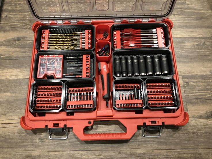 an open tool box filled with tools on top of a wooden floor