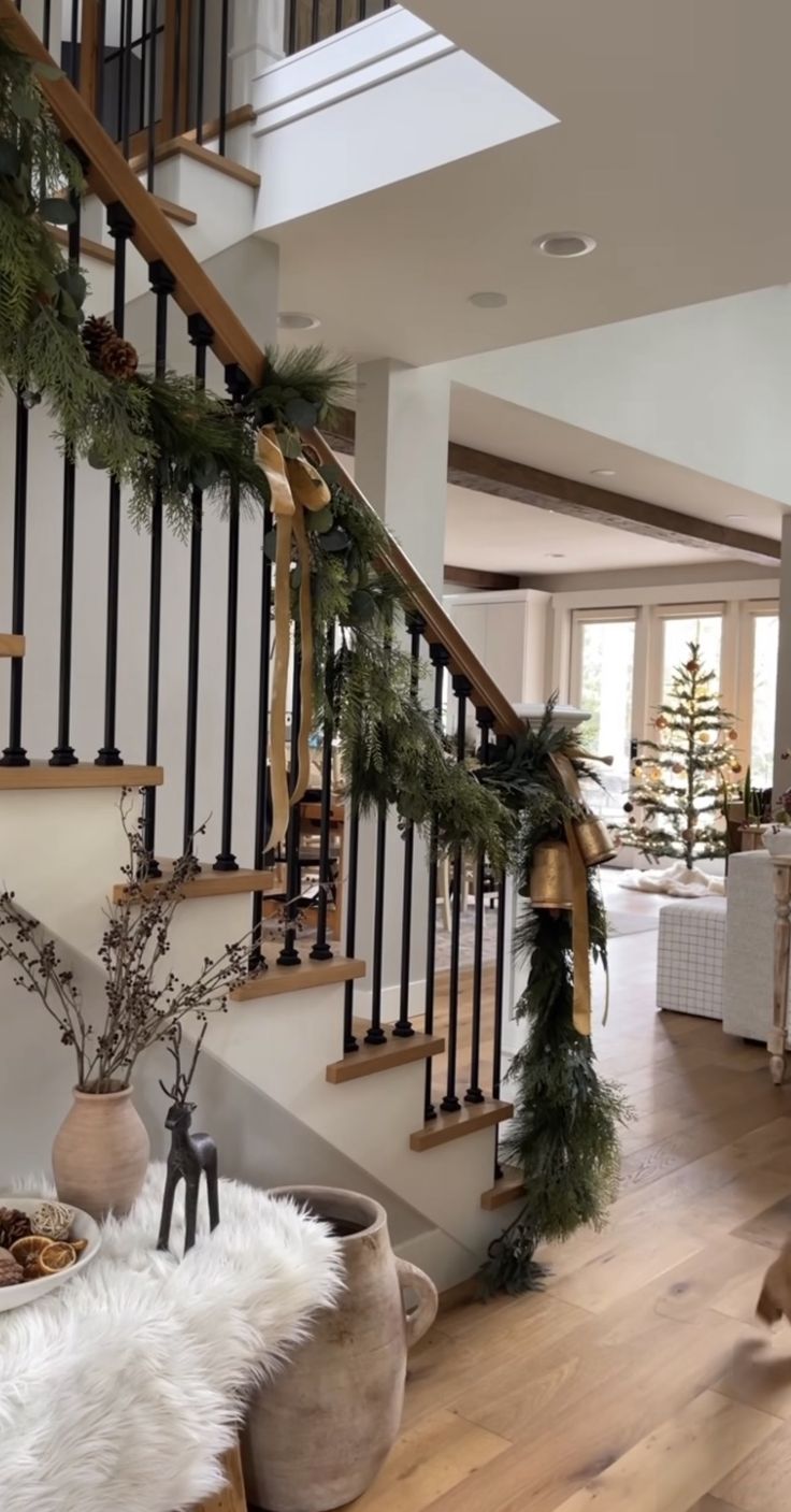 a living room filled with lots of furniture and christmas decorations on top of wooden floors