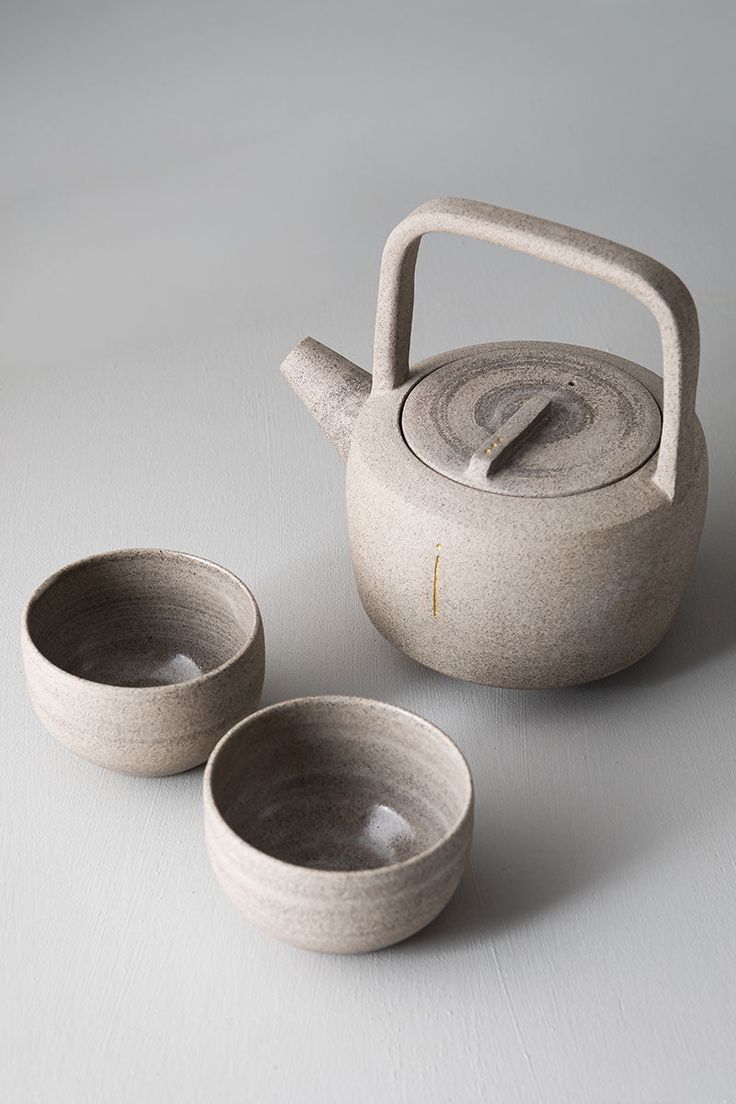 three bowls and a teapot on a table