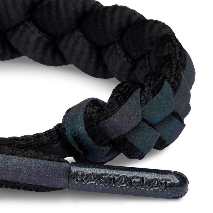 Back by popular demand, the first ever iridescent Rastaclat bracelet. The Void - Medium/Large black braided bracelet features an iridescent strip with reflective technology complemented with tonal hardware and contrast emblems. The iridescence shows a responsive reflection of variant colors when put under direct light or sunlight. -Hand-braided and assembled for a truly custom and one-of-a-kind experience-Adjustable closure to fit a variety of shapes, sizes and ages-Patented barrel for comfort a Rastaclat Bracelet, Mens Braids, Gray Matters, Classic Bracelets, The Void, Braided Bracelet, Black Braids, Custom Bracelets, Braided Bracelets