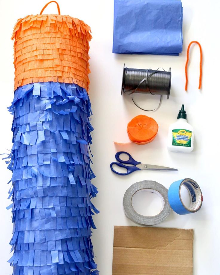 the supplies needed to make an orange and blue pinata