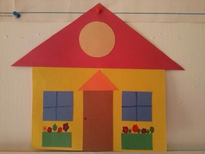 a paper cut out of a house with flowers on the front and windows above it