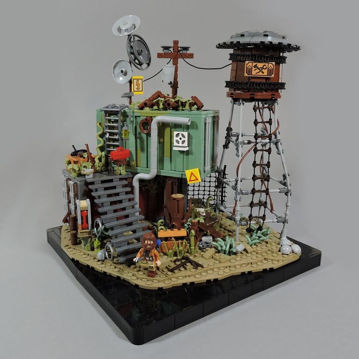 a lego model of a building with a clock tower and other items on top of it