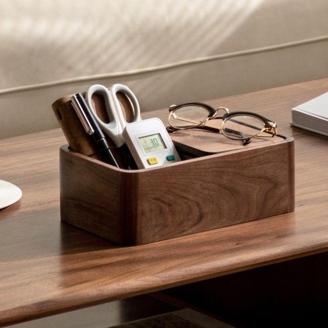 a desk with a laptop, pen and glasses on it