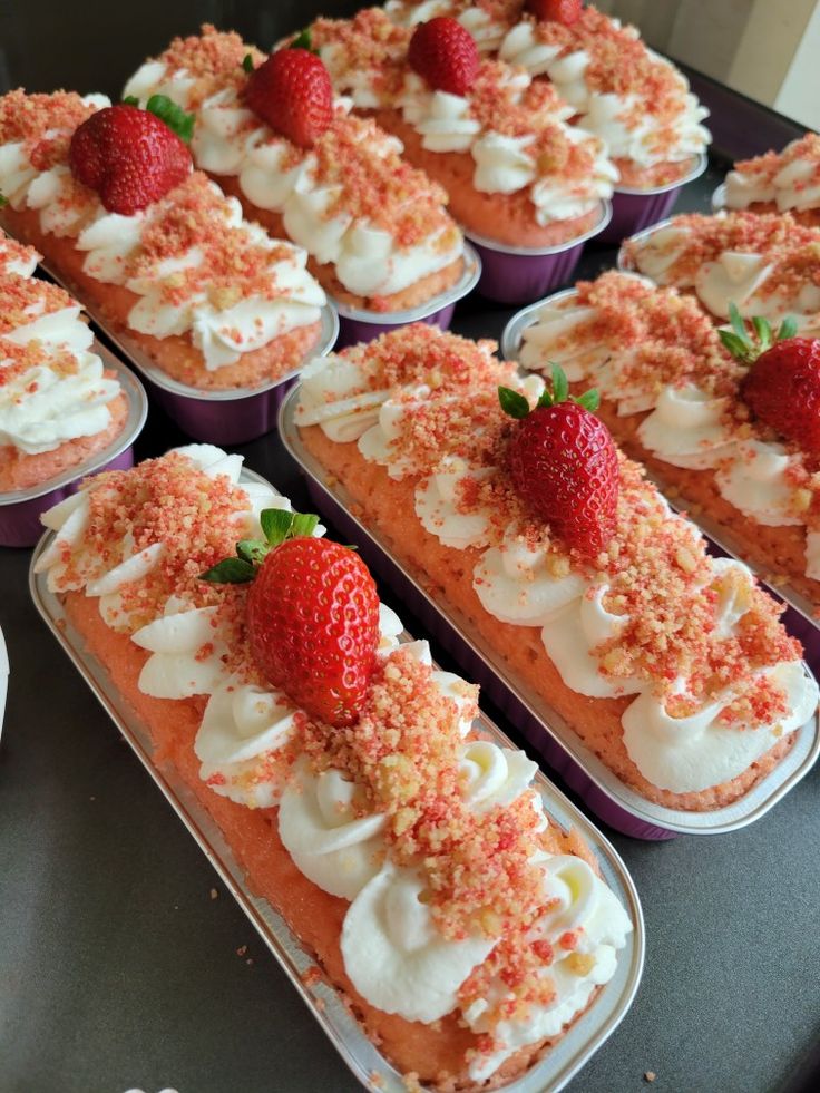 there are many desserts with strawberries on top of each one in the tray