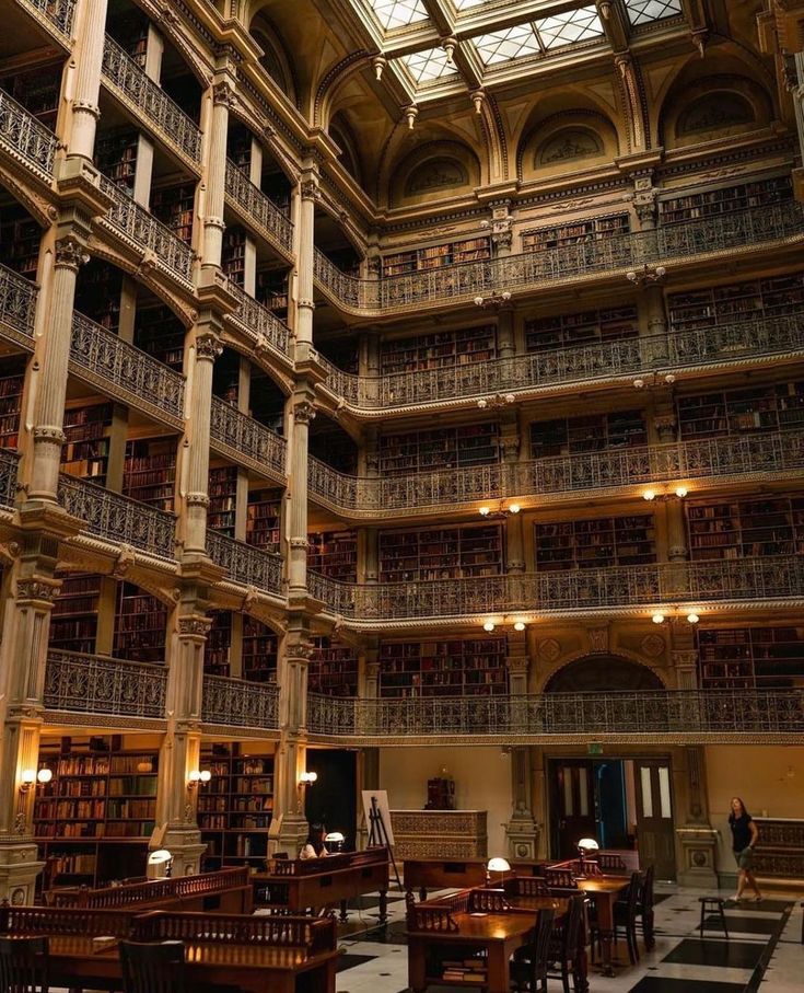 the inside of a library with tables, chairs and bookshelves filled with books