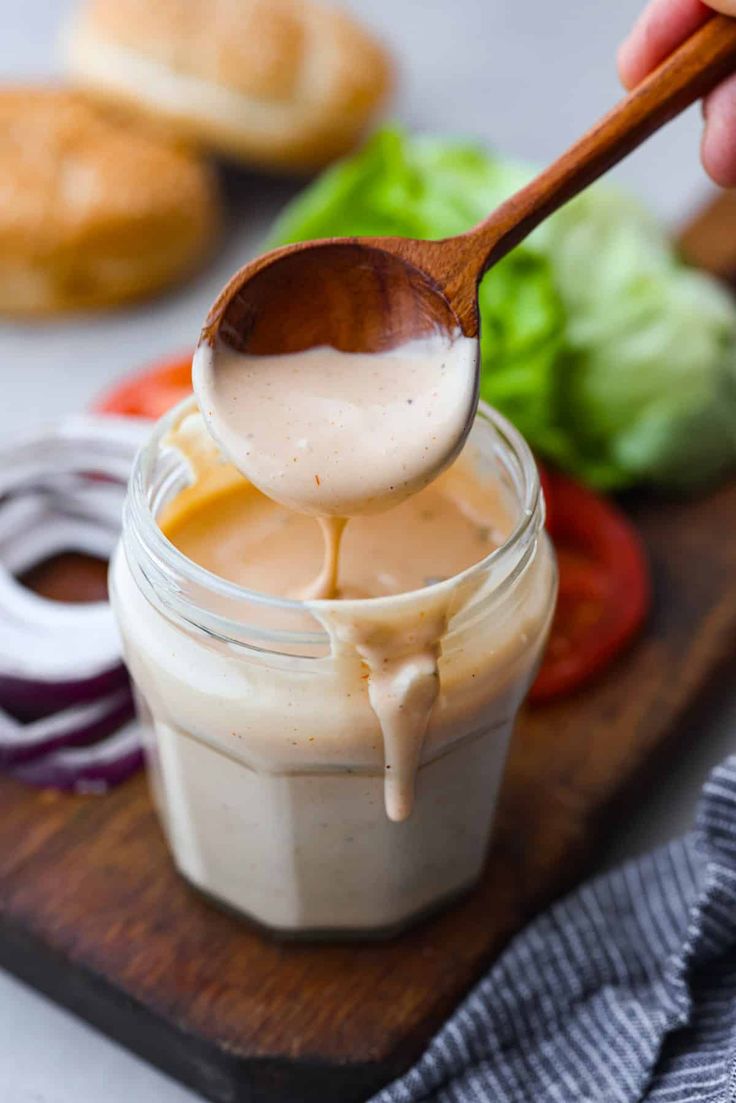 a spoon full of dressing on top of a cutting board