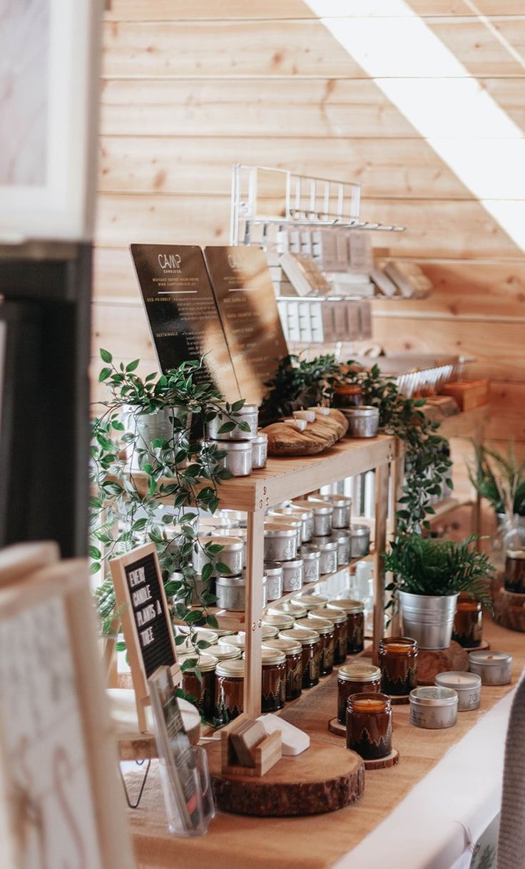 a table topped with lots of jars filled with different types of food next to potted plants