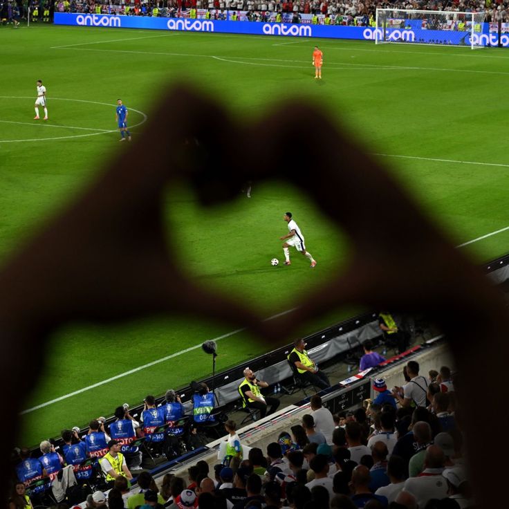 a soccer field with players on it and fans in the stands