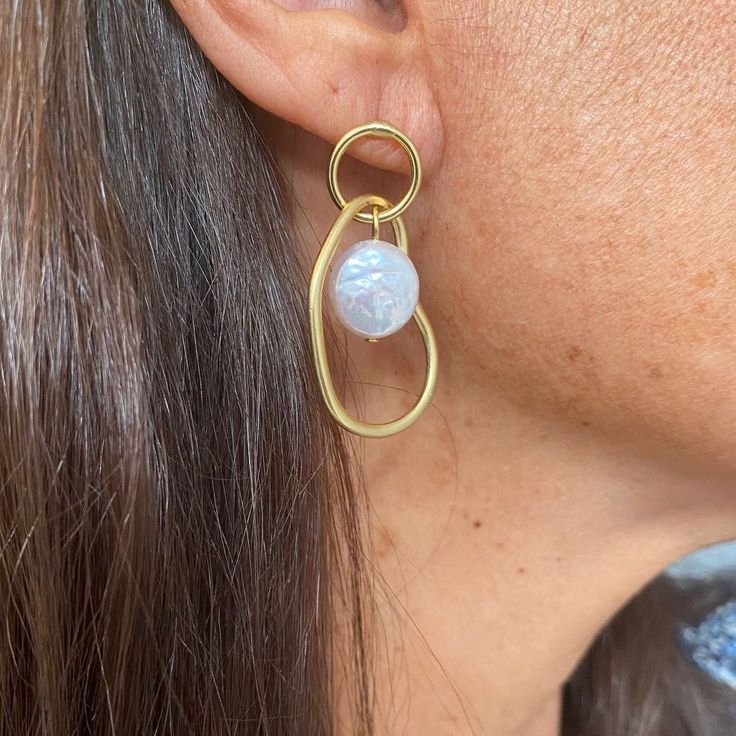 Accessorize elegantly with our Organic Link and Flat Pearl Drop Earrings. Crafted with care, these earrings boast a harmonious blend of organic shapes and lustrous pearls, adding a touch of sophistication to any ensemble. PRODUCT DETAILSMaterials: Pewter alloy base plated with 24-kt gold. Fresh water pearlsMeasurements: 1.5" longEarring closure: Post backEarring weight: ﻿0.13 oz. Modern Pearl Pendant Earrings, Modern Gold Earrings With Pearl Pendant, Elegant Pearl Chain Earrings In Metal, Modern Pearl Earrings For Party, Modern Teardrop Earrings With Pearl Charm, Minimalist Metal Pearl Drop Earrings, Modern Pearl White Earrings With Pearl Charm, Modern Pearl Chain Earrings For Wedding, Modern Pearl Chain Earrings As Gift