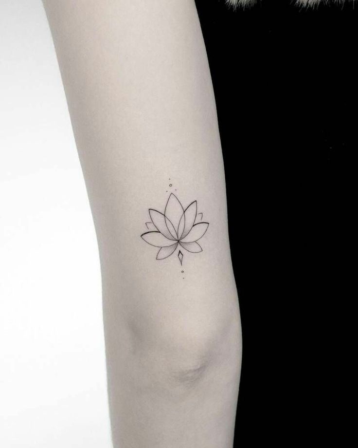 a woman's arm with a small flower tattoo on the left side of her arm