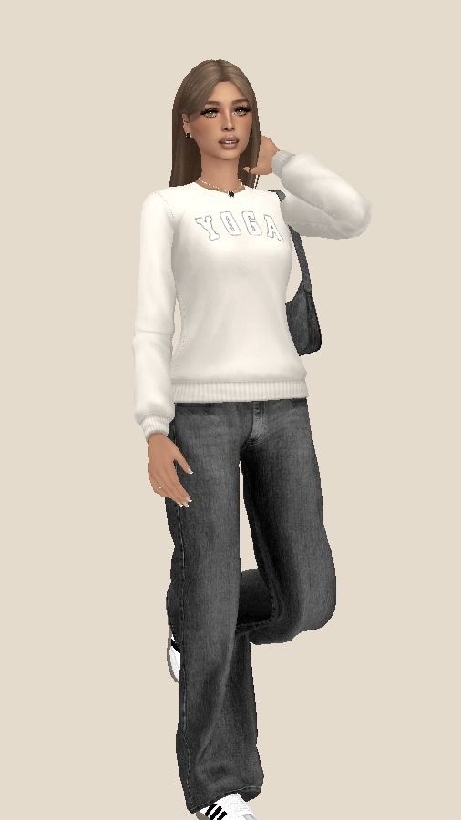 a woman in white sweater and jeans standing next to a gray wall with her hand on her head