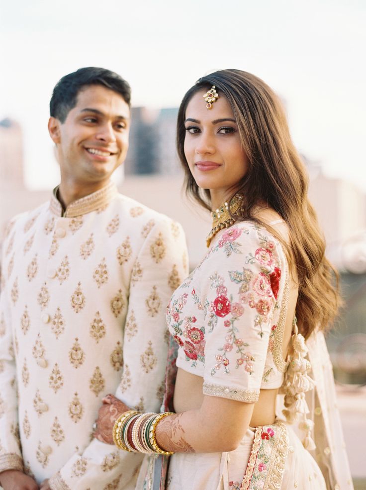 a man and woman standing next to each other in front of a cityscape