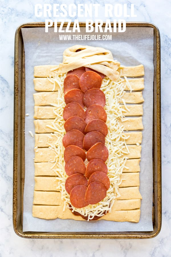 a pizza roll with cheese and pepperoni is on a baking sheet, ready to be cooked