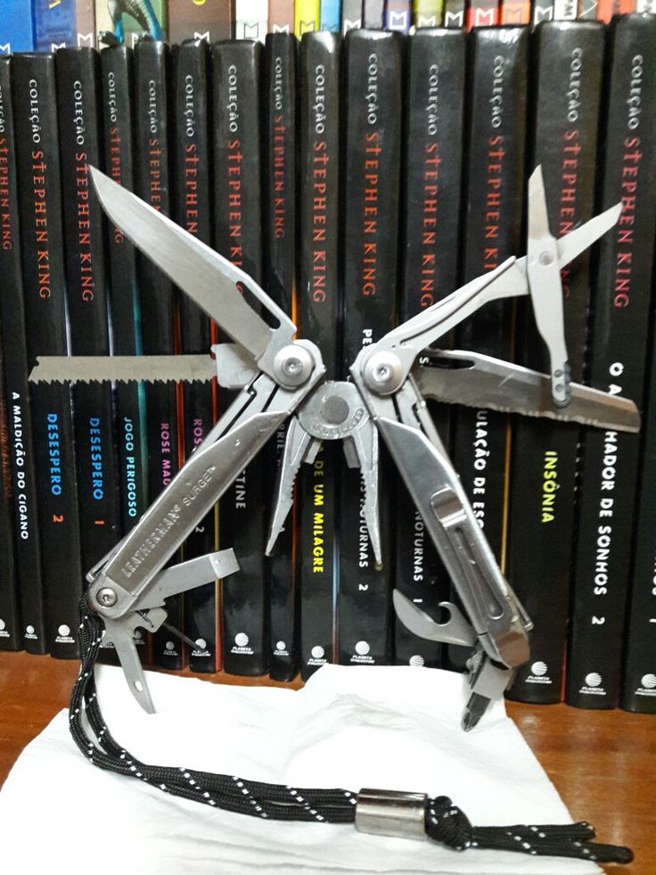 a pair of scissors sitting on top of a white cloth in front of a bunch of books