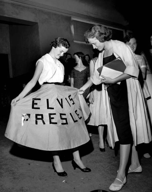 black and white photograph of two women holding a sign