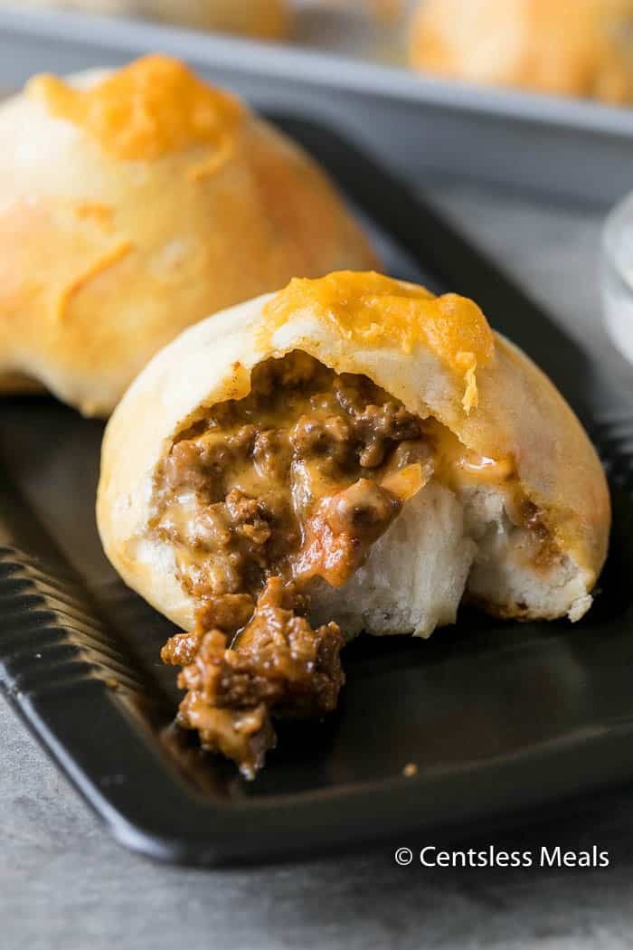 a close up of a plate of food with meat and cheese rolls on the side