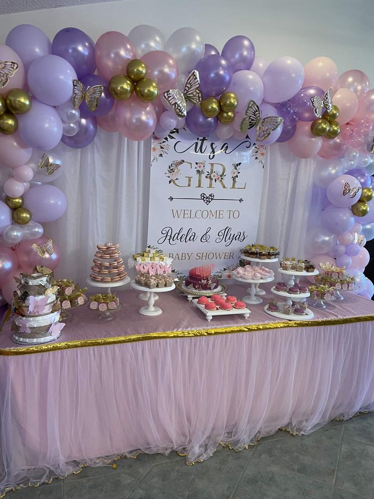 a table topped with lots of cake and balloons