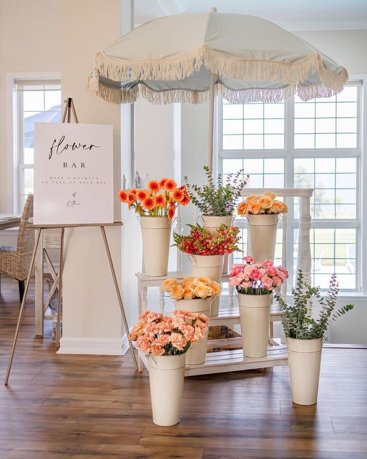 flowers are arranged in flower pots under an umbrella